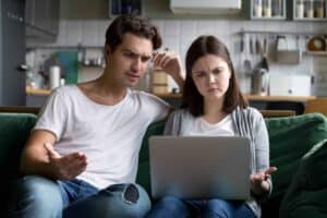 A couple sits together on their living room couch, looking at a laptop with concerned expressions. At Bell Brothers, we understand that home service surprises can be stressful. That’s why our trusted technicians—background-checked for your peace of mind—always provide clear, upfront pricing as part of our No Surprise Guarantee. Proudly serving Northern California communities, we’re dedicated to delivering reliable comfort you can count on.
