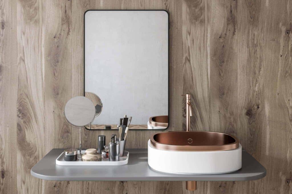 A beautifully modern bathroom vanity showcases a sleek white and copper sink with a matching faucet set against an elegant wood-paneled wall. On the counter, organized grooming essentials rest in stylish trays beside a contemporary rectangular mirror. Bell Brothers is proud to serve Northern California communities with professional, background-checked technicians who provide trusted service you can count on. Enjoy peace of mind with our No Surprise Guarantee and clear, upfront pricing—just one more reason why so many neighbors rely on Bell Brothers for all their home service needs.