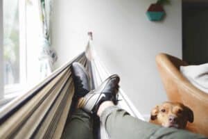 A relaxed homeowner lounges in a hammock near a sunny window, with their loyal brown dog by their side—enjoying total peace of mind thanks to Bell Brothers’ trusted service. Our background-checked technicians deliver comfort and reliability you can count on, always backed by our No Surprise Guarantee and upfront pricing. Proudly serving Northern California communities with integrity and outstanding reputation.