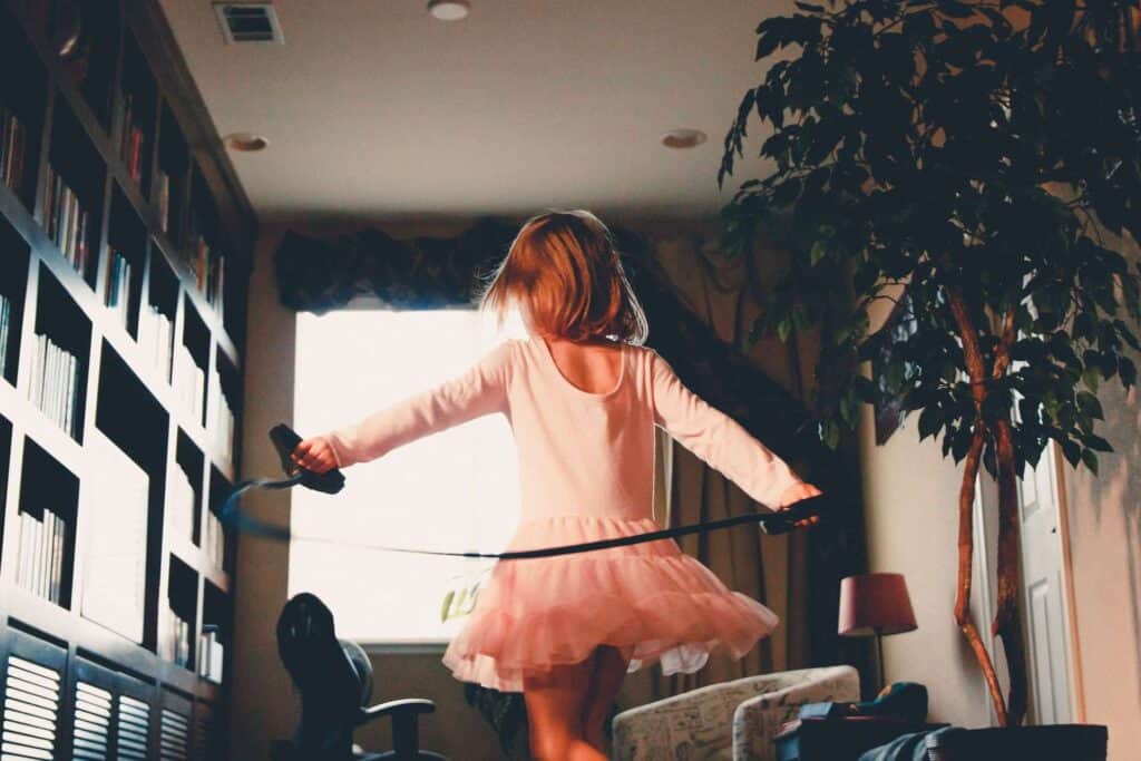A joyful young child in a pink tutu spins playfully in a cozy living room, complete with bookshelves, a large plant, and natural light streaming through the window. At Bell Brothers, we believe your home should always feel this safe and comfortable. That’s why our background-checked technicians deliver trusted service backed by our No Surprise Guarantee and upfront pricing—earning us a strong reputation across Northern California communities.