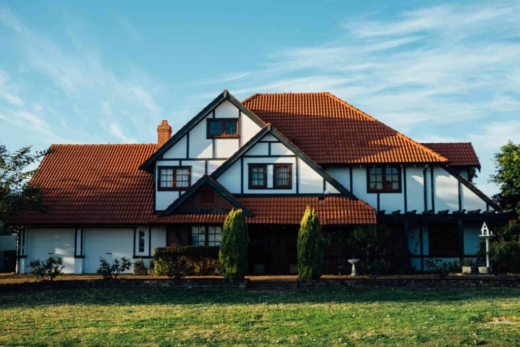 A beautiful two-story home with a red tile roof and crisp white walls sits beneath a clear blue sky, its well-kept yard reflecting care and attention. At Bell Brothers, we proudly serve homes like this throughout Northern California—providing trusted, professional service from background-checked technicians. With our No Surprise Guarantee and transparent, upfront pricing, you can always count on fair treatment and peace of mind in every visit.