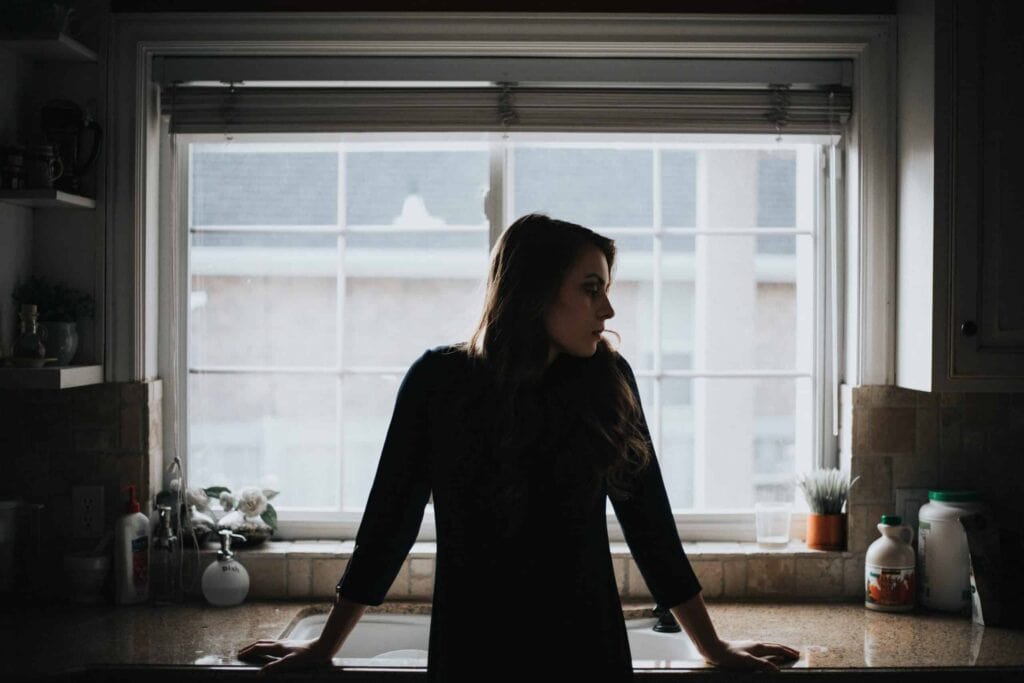 A woman stands at her kitchen sink, bathed in natural daylight as she looks out the window with confidence and peace of mind. She feels reassured knowing Bell Brothers’ trusted, background-checked technicians provide reliable service backed by our No Surprise Guarantee, upfront pricing, and a strong reputation throughout Northern California communities.