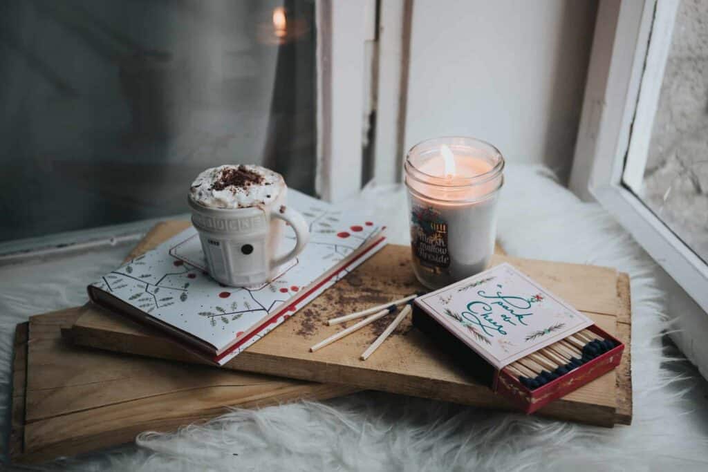 A cozy scene featuring a mug of hot chocolate, a lit candle, and a notebook on a wooden tray near a window—capturing the warmth and comfort Bell Brothers brings to Northern California homes. As your trusted local experts, we ensure peace of mind with our No Surprise Guarantee, thoroughly background-checked technicians, transparent upfront pricing, and exceptional service trusted by communities across the region.