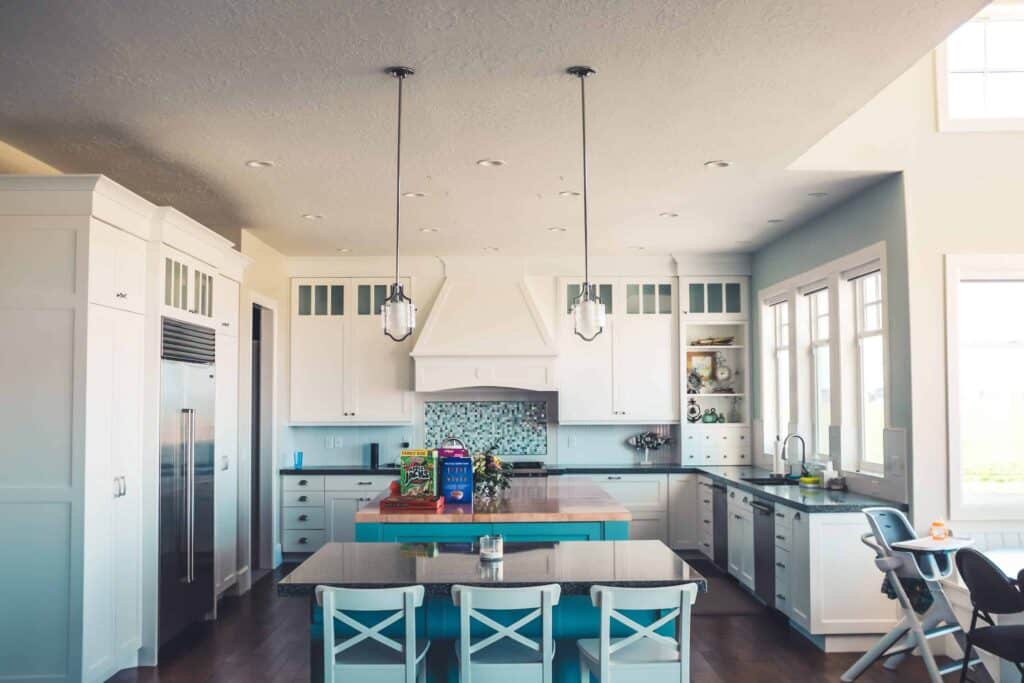 Bright, modern kitchen featuring white cabinets, a spacious island with high chairs, stylish pendant lighting, and abundant natural light from multiple windows. Bell Brothers’ commitment to trusted service—including background-checked technicians, upfront pricing, and our No Surprise Guarantee—has earned us a strong reputation in Northern California communities.