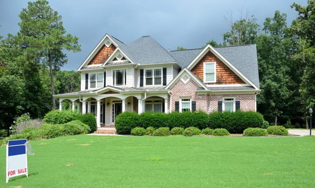A well-maintained two-story suburban home with a lush green lawn and inviting brick-and-wood exterior sits surrounded by trees and bushes. A “For Sale” sign is displayed in the front yard. Bell Brothers is known throughout Northern California communities for their trusted service, featuring background-checked technicians, upfront pricing, and our signature No Surprise Guarantee—so you always know who’s at your door and what to expect.