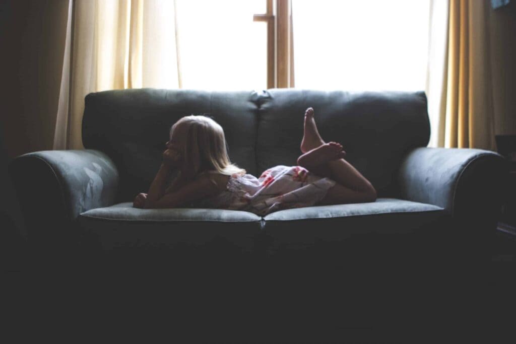 A young child relaxes comfortably on a dark sofa in front of a sunlit window, feeling safe and secure—just like our customers across Northern California. At Bell Brothers, our No Surprise Guarantee means you can always count on upfront pricing and trusted service from thoroughly background-checked technicians. That’s why families throughout the region rely on us for honest, professional care every time.