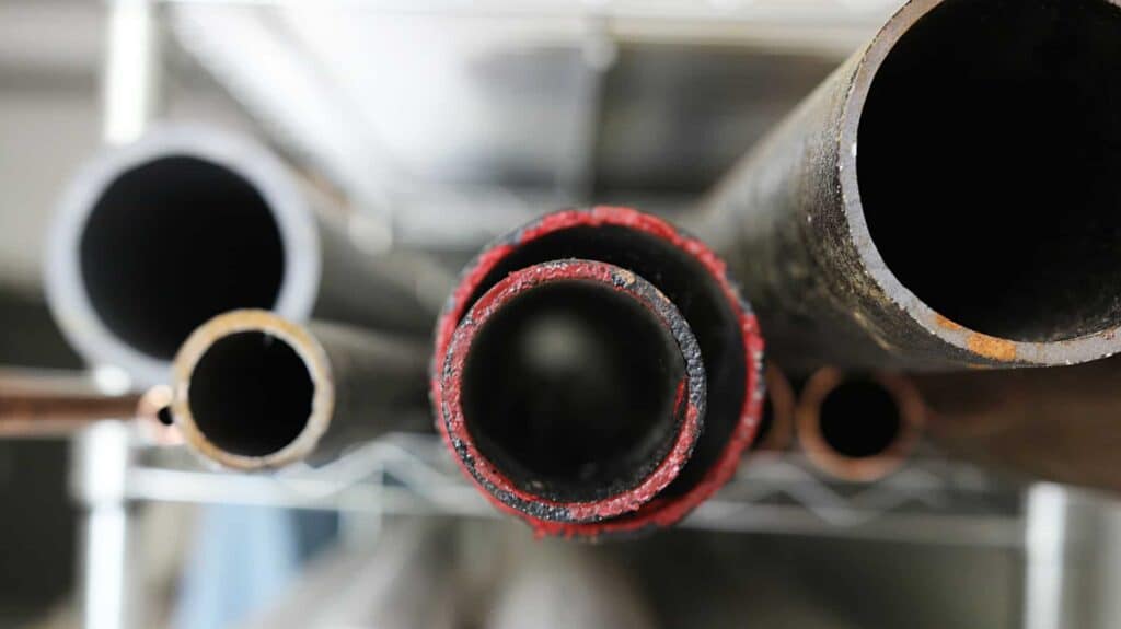 A close-up view of several metal pipes, neatly arranged horizontally in varying sizes and conditions. As Northern California’s trusted home service experts, Bell Brothers ensures every job is handled with care by friendly, background-checked technicians. Enjoy peace of mind with our No Surprise Guarantee and upfront pricing—just a few reasons we’re proud to serve our local communities.