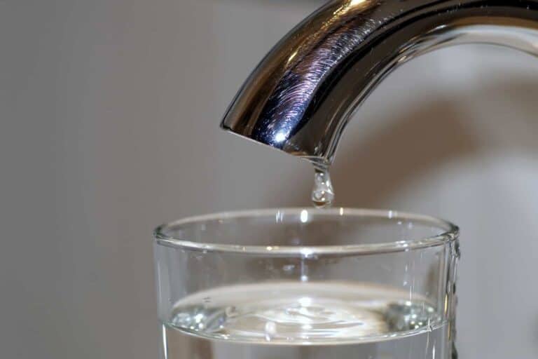 A single drop of water falls from a shiny metal faucet into a clear glass, symbolizing reliable plumbing service. With Bell Brothers’ trusted technicians—background-checked for your peace of mind—and our No Surprise Guarantee featuring upfront pricing, you can count on honest, expert care for homes and businesses throughout Northern California.