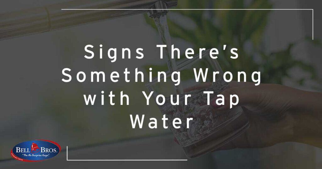 A hand holds a glass beneath a running kitchen faucet, with the text "Signs There’s Something Wrong with Your Tap Water" displayed. The Bell Bros. logo appears in the lower left corner, representing our trusted service across Northern California. Count on Bell Brothers’ No Surprise Guarantee, background-checked technicians, and upfront pricing for peace of mind every time we’re in your home.