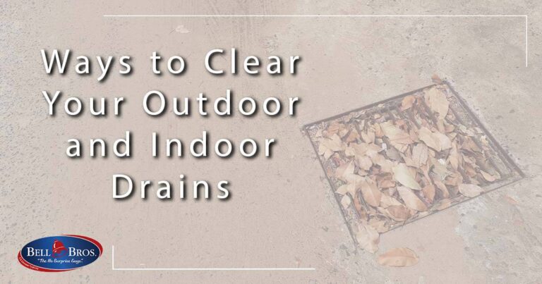 A square drain covered with dry leaves on a concrete surface represents typical challenges faced with outdoor and indoor drains. Text overlay reads: "Ways to Clear Your Outdoor and Indoor Drains." The Bell Bros. logo appears in the bottom left corner, symbolizing our commitment to trusted service across Northern California. Count on Bell Brothers’ background-checked technicians, clear upfront pricing, and our No Surprise Guarantee—so you’ll always know what to expect before any work begins.