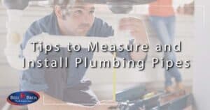 A Bell Brothers technician, thoroughly background-checked and trusted across Northern California, carefully measures under-sink plumbing pipes with a tape measure. The Bell Bros logo is displayed in the corner alongside text: “Tips to Measure and Install Plumbing Pipes.” Discover easy, step-by-step guidance for your home plumbing projects—enjoy upfront pricing and our signature No Surprise Guarantee for total peace of mind.