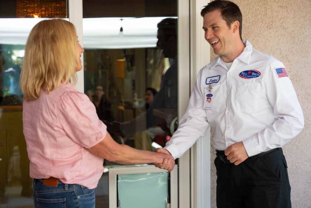 A Bell Brothers technician greets a Sacramento homeowner with a handshake, offering trusted, No Surprise service and upfront pricing.