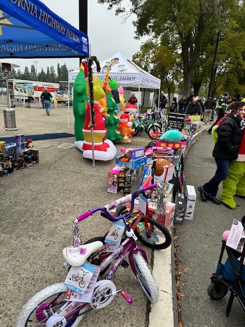Bicycles, toys, and festive décor by a CHP tent at a Bell Brothers event—trusted service with upfront pricing and no surprises.