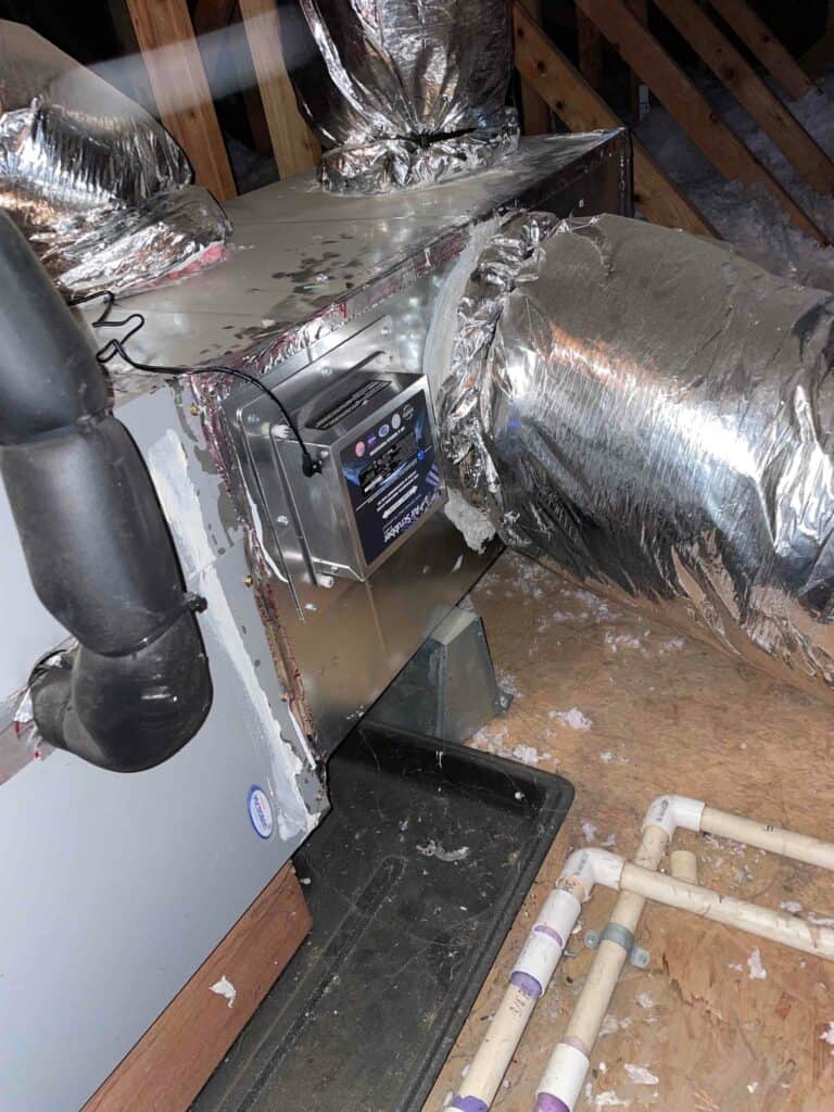 A whole-home humidifier is expertly installed on an attic HVAC duct by Bell Brothers’ background-checked team, with upfront pricing.