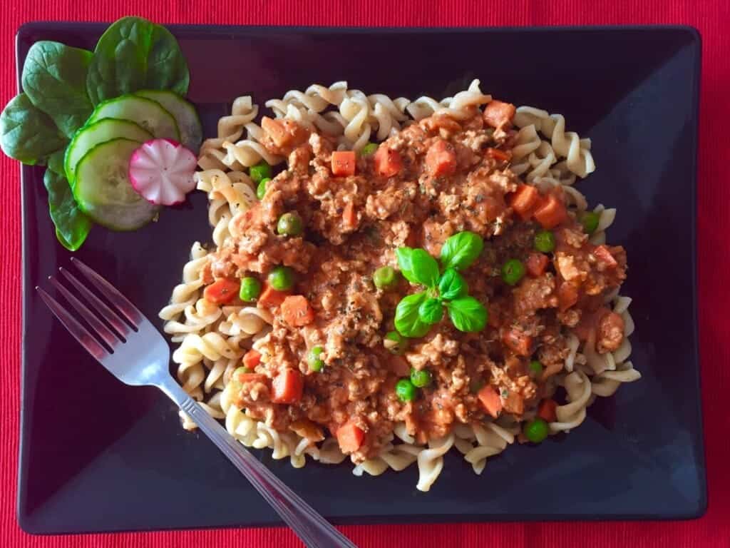 Makaron w sosie pomidorowym z mięsem mielonym oraz groszkiem i marchewką