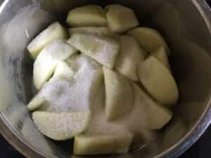 Jabłka krojone w ćwiartki w garnku