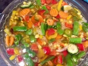 Bulion wlewany do naczynia z ryżem i warzywami