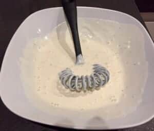 sos czosnkowy mieszany łyżką w małej misce