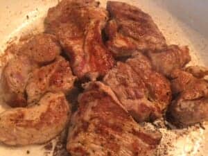 Plastry karkówki w kapuście przed pieczeniem