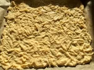 Ciasto serowe rozprowadzone na blasze do przygotowania rolady