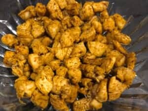 pierwsza warstwa mięsa w warstwowej sałatce z kurczakiem