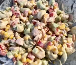 mieszanie sałatki z tortellini i pysznym sosem