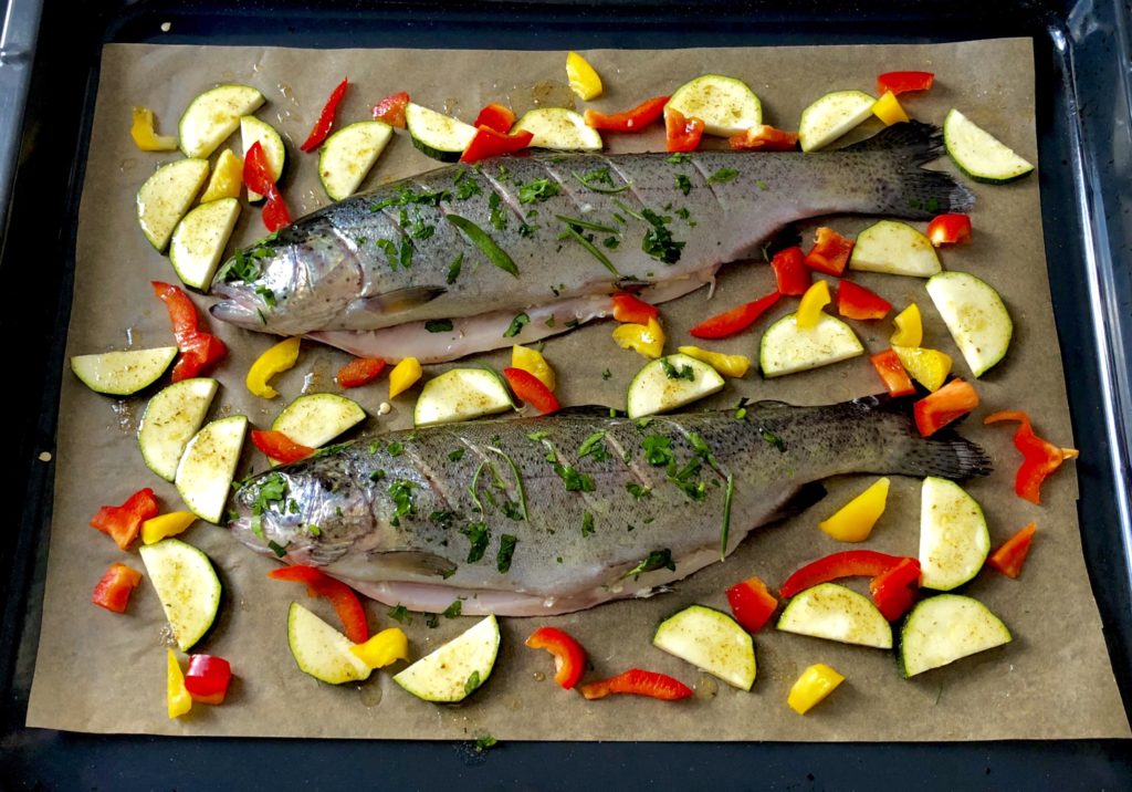 Pstrąg pieczony w pietruszce, z masłem czosnkowym i warzywami