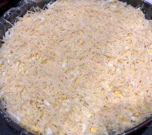 Warstwa startego sera i jajek w sałatce leśnej polanej