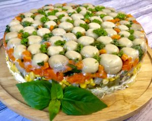 sałatka leśna polana ze śledziem na talerzu