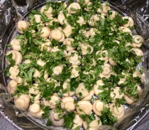 Dodawanie zieleniny do warstwy pieczarek w sałatce