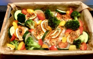 dorsz z warzywami pieczony w piekarniku w trakcie przygotowania