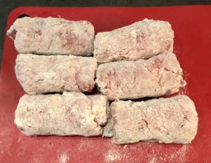 Obtaczanie roladek schabowych w mące przed smażeniem