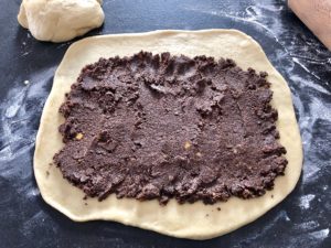 nakładanie masy makowej na ciasto drożdżowe