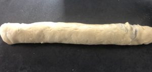 Zwijanie ciasta z makiem w rulon do przygotowania babki