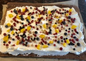 Nakładanie kremu i owoców na roladę żyrafa