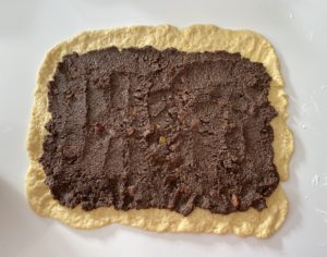 Nakładanie masy do przepisu na makowiec na Wielkanoc