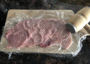 Cienko rozbite mięso na sznycle po wiedeńsku przed panierowaniem