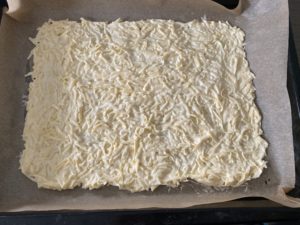 Ciasto serowe rozłożone na blasze do rolady z sera żółtego