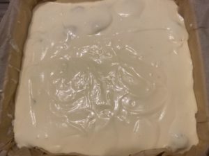 Wylewanie masy serowej na kulki makowe do sernika z kulkami