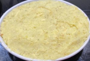 Układanie warstwy ziemniaków na mięsie