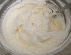 Ubijanie śmietany i mascarpone do kremu rolady z wiśniami
