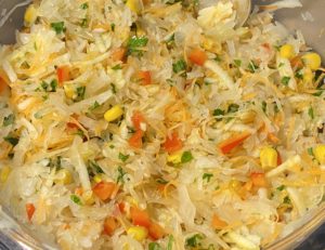 Mieszanie składników na soczystą surówkę z kiszonej kapusty