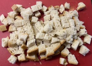 Pokrojony w kostkę chleb na grzanki do zupy czosnkowej.