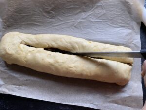 Przecinanie makowca przed zaplataniem zawijańca z makiem