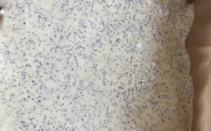 Przekładanie ciasta makowego do formy przed pieczeniem