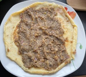 Nakładanie farszu na naleśnik do krokietów