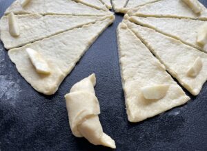 Zawijamy ciasto tworząc rogaliki z jabłkami