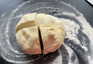 Ciasto podzielone na cztery równe części do przygotowania rogalików z kajmakiem