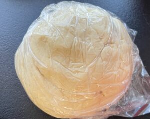 Uformowana kula ciasta owinięta i schłodzona przed przygotowaniem rogalików z kajmakiem