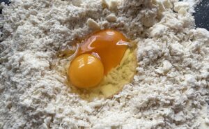 Składniki łączone w ciasto na paszteciki z serem i pieczarkami